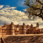 Historical Gwalior Fort. It was built by Raja Man Singh Tomar in the 15th century. This great Fort spreads out over an area of 3 square km and is built at a vantage height of 100 m above the city. This fort is bounded by solid walls of sandstone, which encloses three temples, six palaces and a number of water tanks. There is gruesome Jauhar Kund, where the women of the harem burnt themselves to death when the was King of Gwalior defeat in 1232 AD.